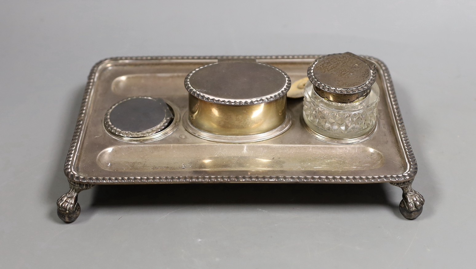 A late Victorian silver rectangular inkstand, with two wells and central lidded compartment, (glass well missing), on claw and ball feet, John Grinsell & Sons, London, 1895, 20.4cm, 12.9oz.